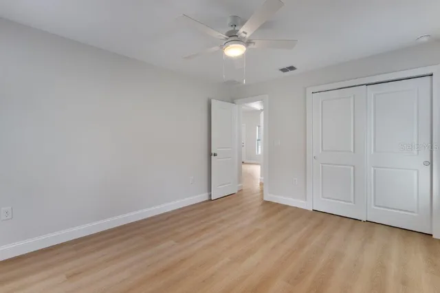 a view of an empty room and a ceiling fan window