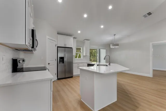 a kitchen with stainless steel appliances granite countertop a sink stove and refrigerator