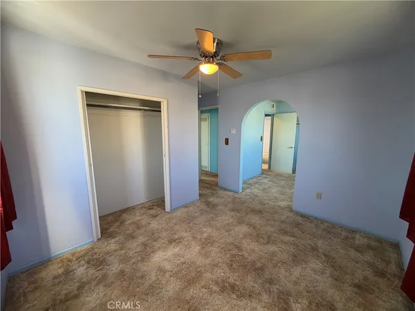 an empty room with windows and closet