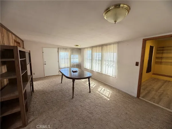 a view of an empty room with a fireplace and a window