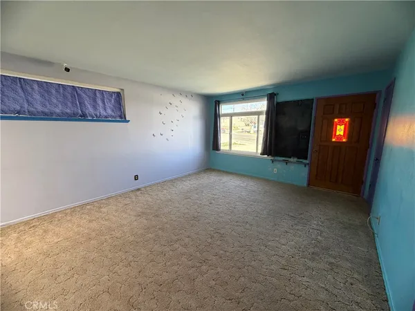 an empty room with a window and fireplace