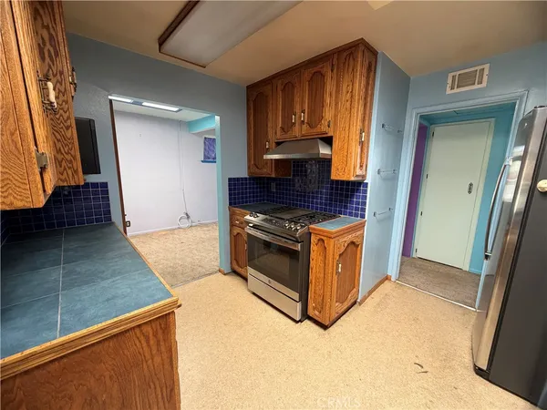 a kitchen with stainless steel appliances granite countertop a stove a sink and a refrigerator