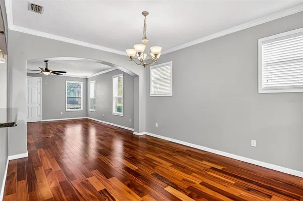 a view of a livingroom with wooden floor and a kitchen space