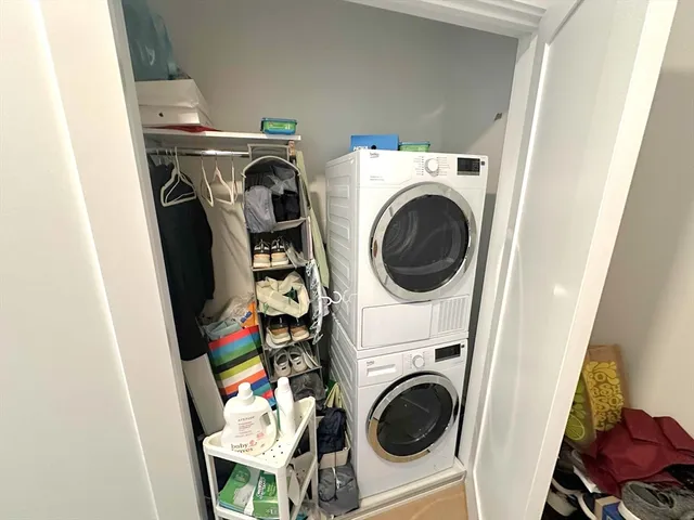 a utility room with dryer washer and a view of living room