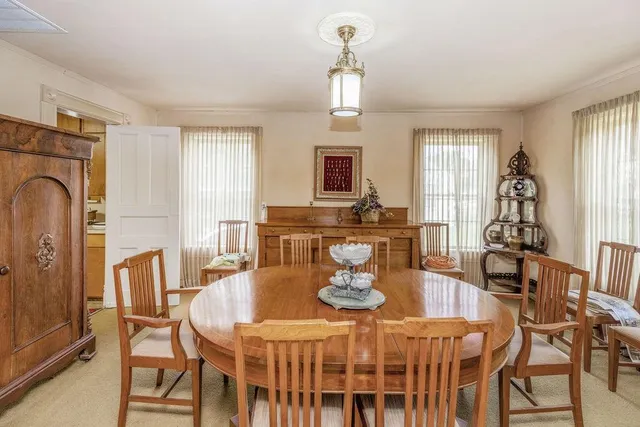 a dining room with furniture a chandelier and wooden floor