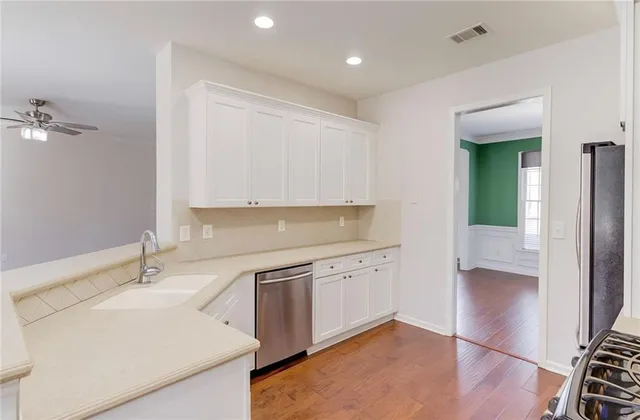 an empty room with chandelier fan and windows