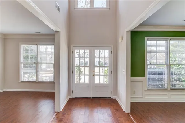 an empty room with wooden floor and windows