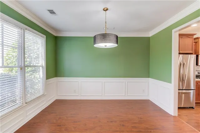 an empty room with wooden floor fireplace and windows