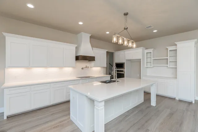 a kitchen with kitchen island a sink stainless steel appliances and cabinets