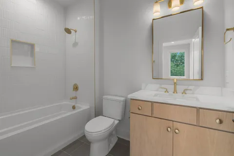 a bathroom with a sink toilet vanity and tub