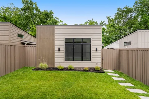 a view of backyard with small cabin and wooden fence