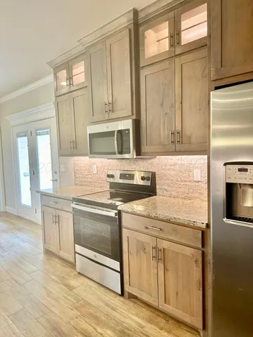 a kitchen with stainless steel appliances granite countertop a stove a sink and a microwave