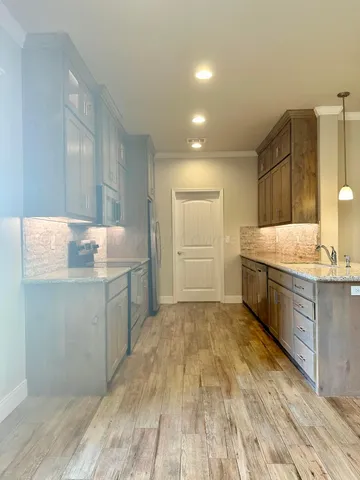 a spacious bathroom with a granite countertop sink a mirror and a bathtub