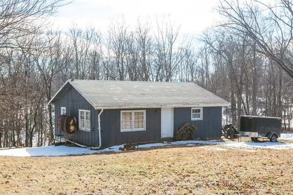 a front view of a house with a yard covered in snow