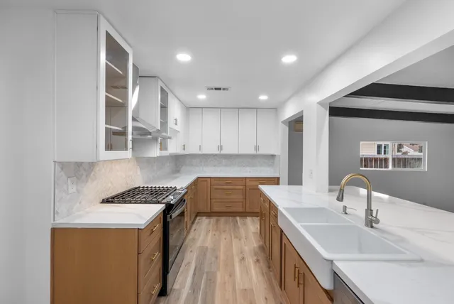 a kitchen with a sink stove and cabinets