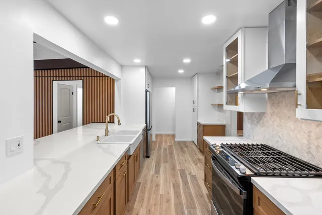 a kitchen with kitchen island a sink stove and cabinets
