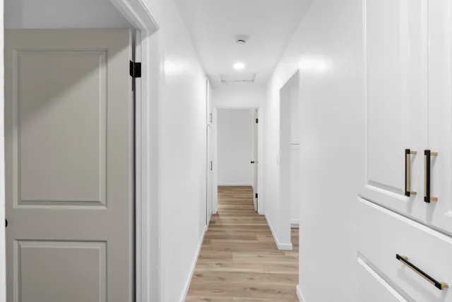 a view of a hallway with wooden floor and staircase