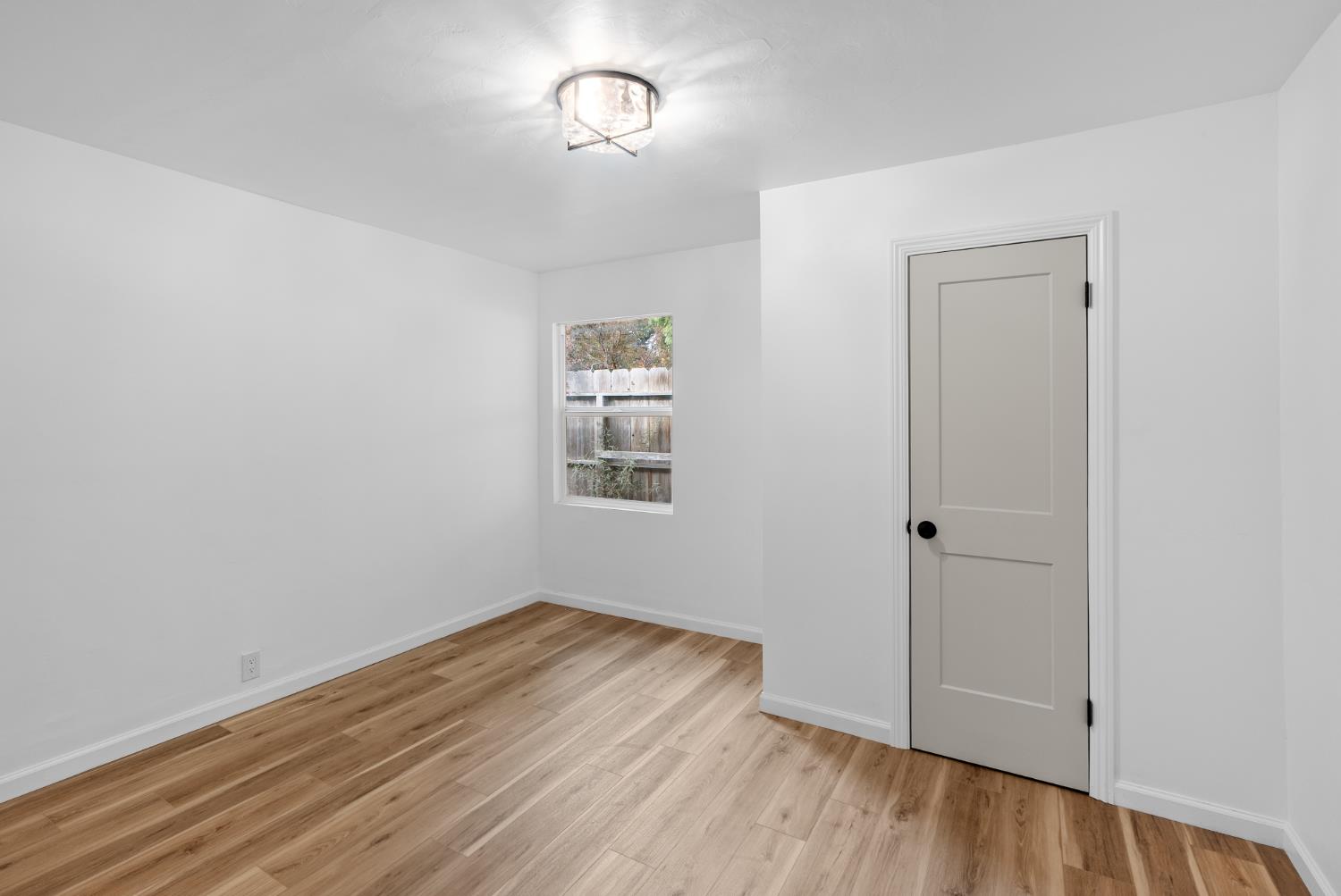 1125 Wellesley Avenue Modesto, CA 95350 - Photo 29 of 43 an empty room with wooden floor and windows