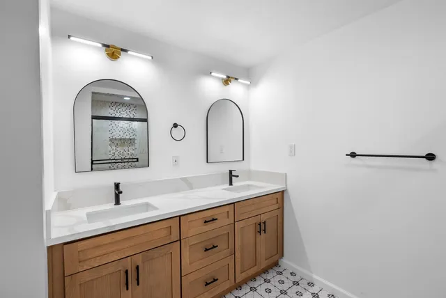 a bathroom with a double vanity sink and a mirror
