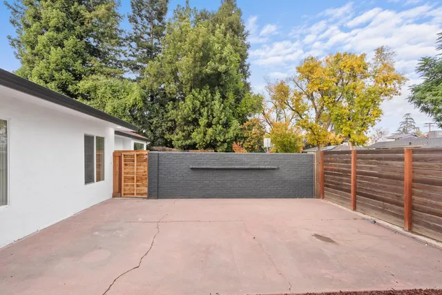 a view of backyard and wooden fence