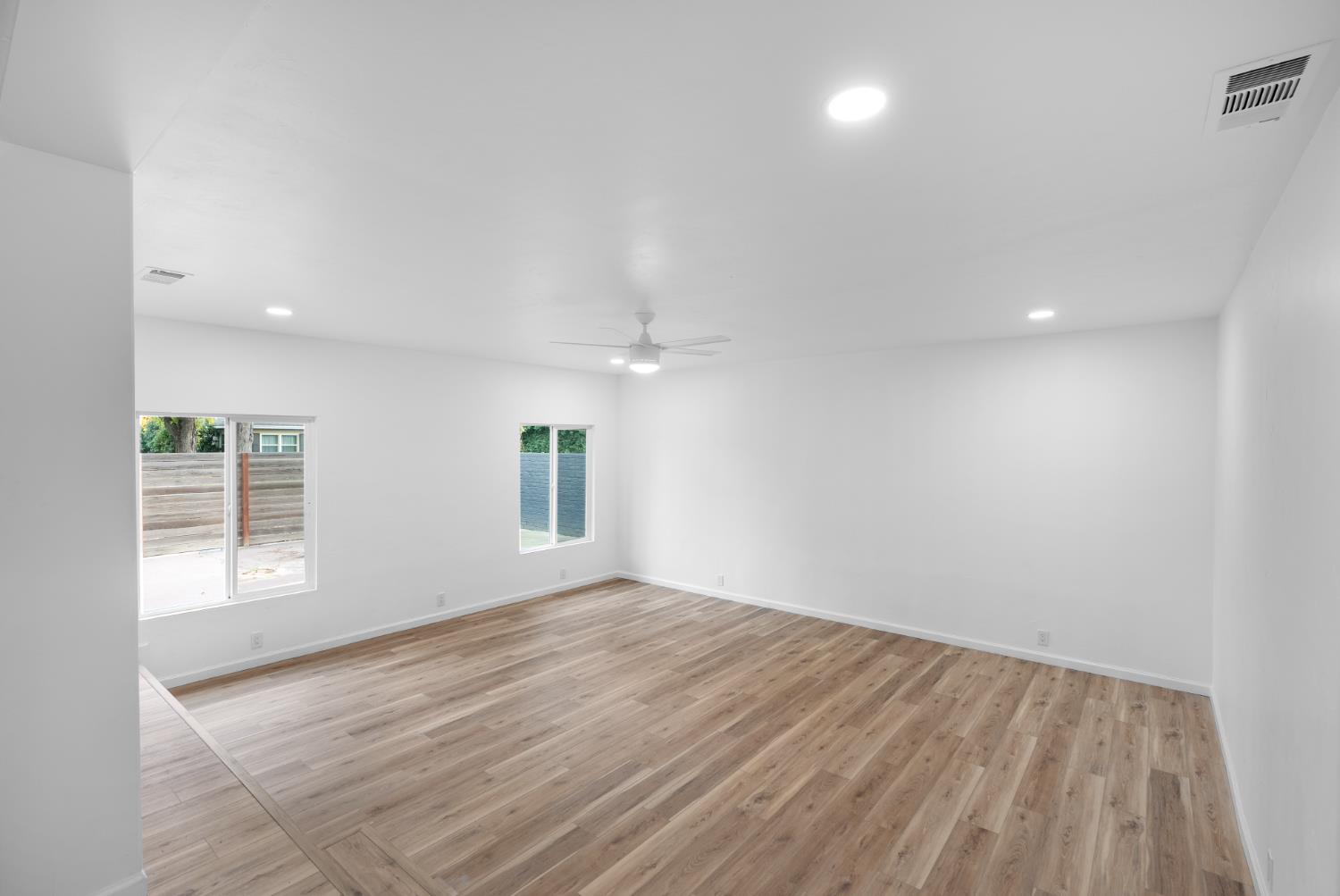 1125 Wellesley Avenue Modesto, CA 95350 - Photo 5 of 43 an empty room with wooden floor and windows