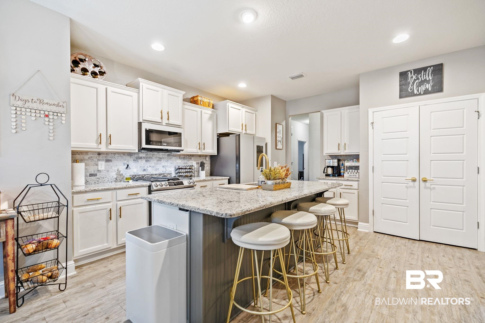 31402 Hoot Owl Road Daphne, AL 36527 - Photo 8 of 43 Kitchen with light wood-type flooring, stainless steel appliances, and white cabinets