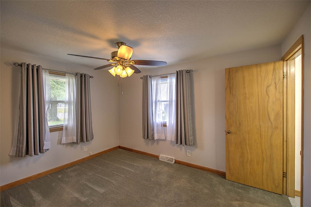 2913 South Danny Drive Decatur, IL 62521 - Photo 19 of 31 an empty room with windows and chandelier fan