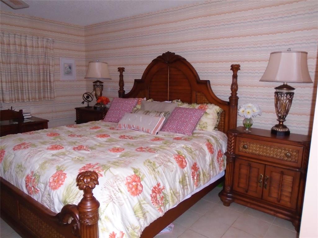 3165 Northeast 48th Court, Unit 110 Lighthouse Point, FL 33064 - Photo 17 of 49 a bedroom with a bed and a dresser