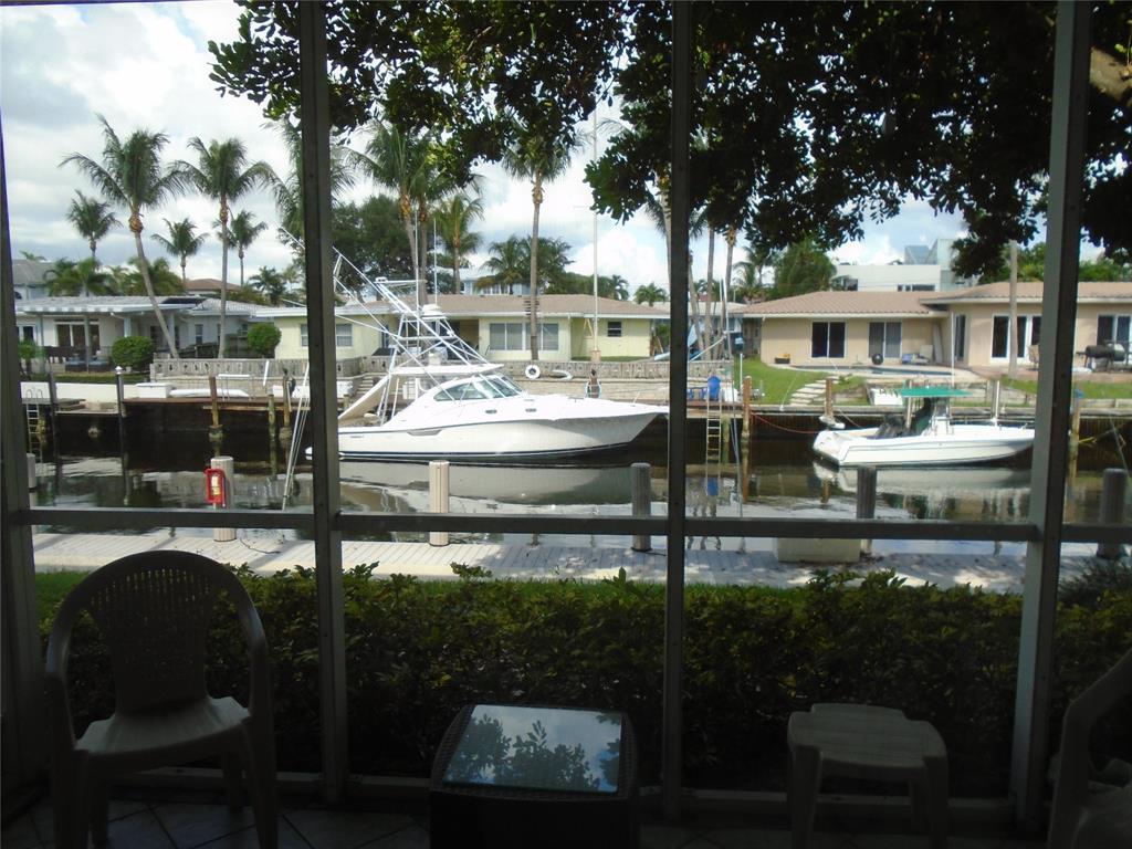 3165 Northeast 48th Court, Unit 110 Lighthouse Point, FL 33064 - Photo 26 of 49 a patio with table and chairs and potted plants