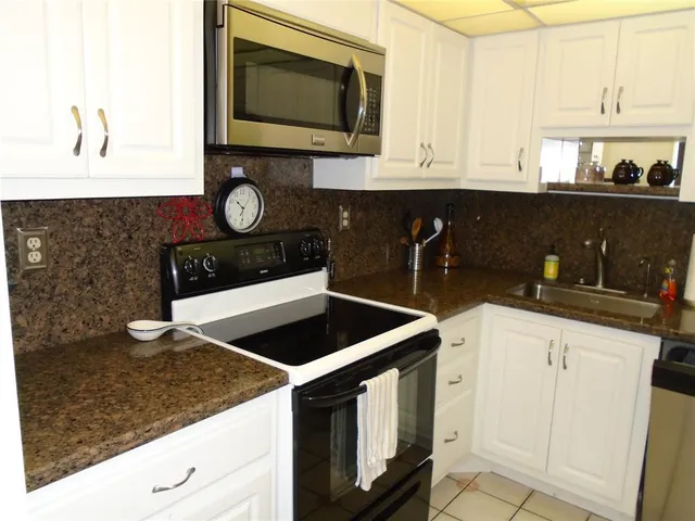 a kitchen with stainless steel appliances granite countertop a refrigerator and a stove top oven