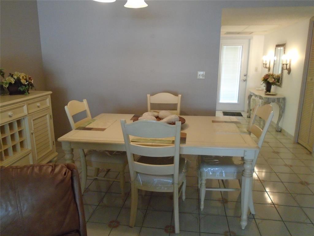 3165 Northeast 48th Court, Unit 110 Lighthouse Point, FL 33064 - Photo 6 of 49 a view of a dining room with furniture and wooden floor