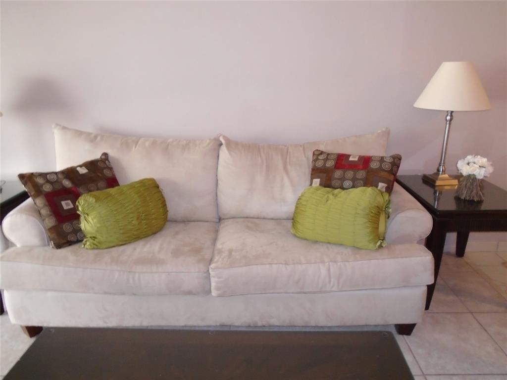 3165 Northeast 48th Court, Unit 110 Lighthouse Point, FL 33064 - Photo 9 of 49 a living room with furniture and a lamp