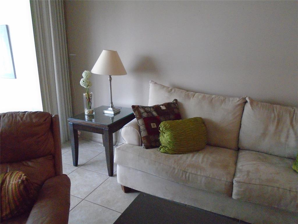 3165 Northeast 48th Court, Unit 110 Lighthouse Point, FL 33064 - Photo 10 of 49 a living room with furniture and a lamp