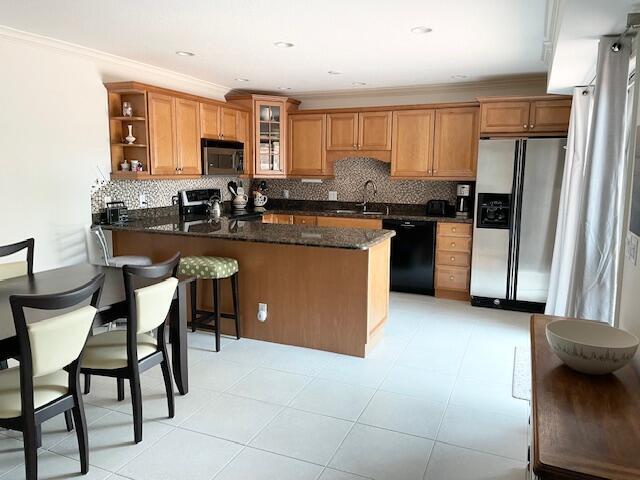 1420 Ocean Way, Unit 23C Jupiter, FL 33477 - Photo 6 of 32 a kitchen with kitchen island granite countertop wooden cabinets a counter top space a sink and appliances