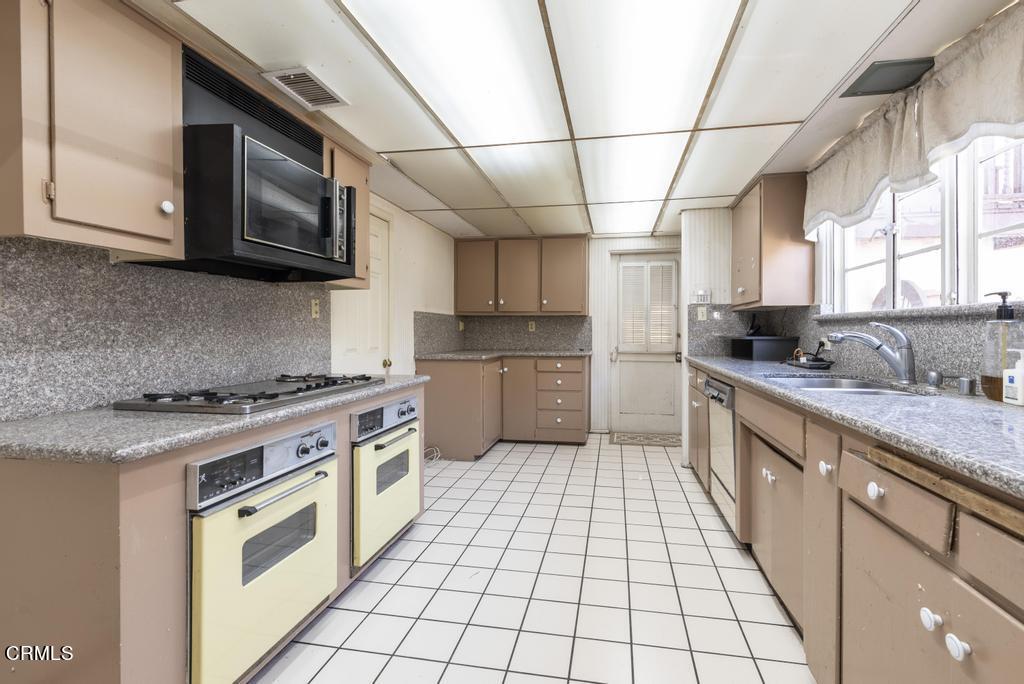 893 Gainsborough Drive Pasadena, CA 91107 - Photo 19 of 62 a kitchen with stainless steel appliances granite countertop a stove a sink and a microwave