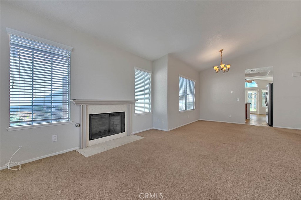 39220 Cala Del Valle Murrieta, CA 92562 - Photo 8 of 47 a view of empty room with a fireplace and windows
