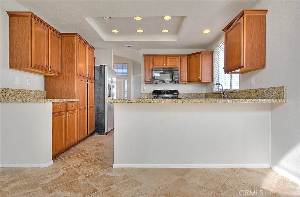 39220 Cala Del Valle Murrieta, CA 92562 - Photo 10 of 47 a kitchen with stainless steel appliances granite countertop a refrigerator a stove top oven a sink and dishwasher