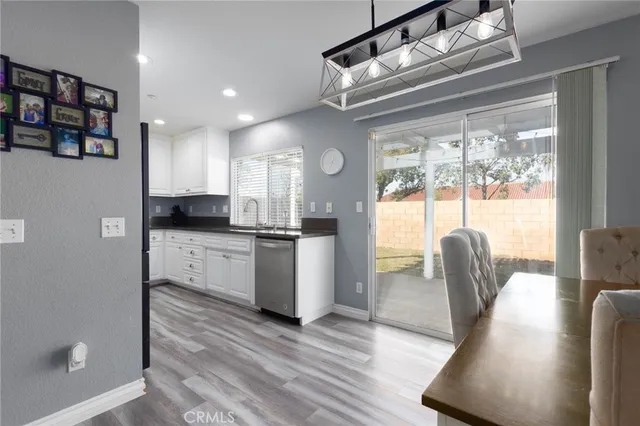 a kitchen with granite countertop a refrigerator and wooden floor