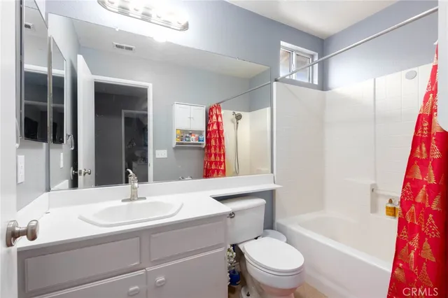 a bathroom with a sink a toilet a mirror a vanity and shower