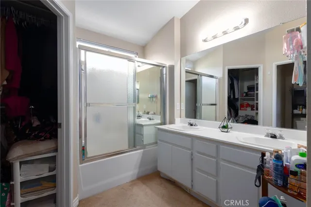 a bathroom with a double vanity sink mirror and shower
