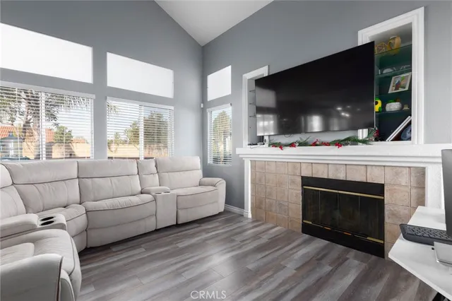 a living room with furniture a flat screen tv and a fireplace