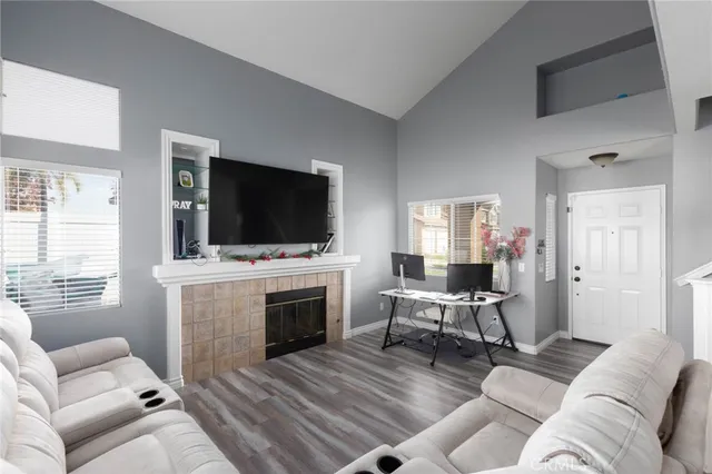 a living room with furniture a flat screen tv and a fireplace