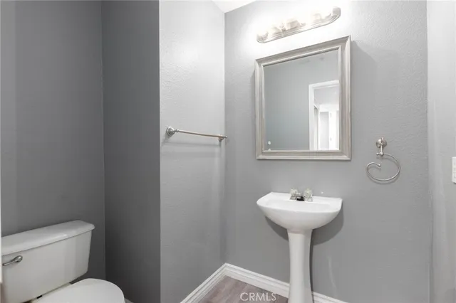 a bathroom with a sink toilet and mirror