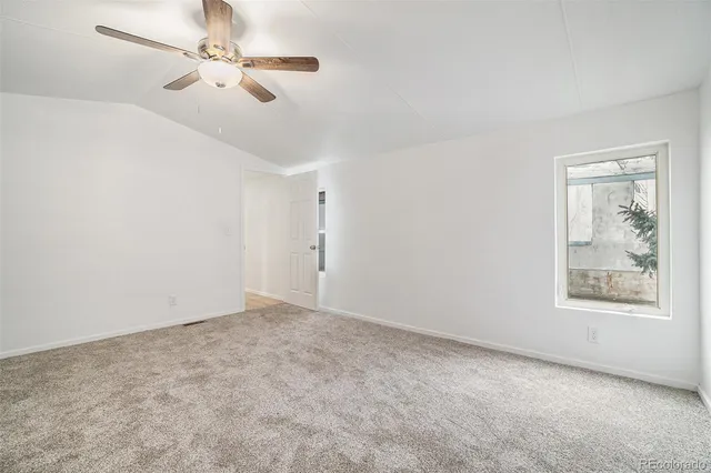 an empty room with closet and windows