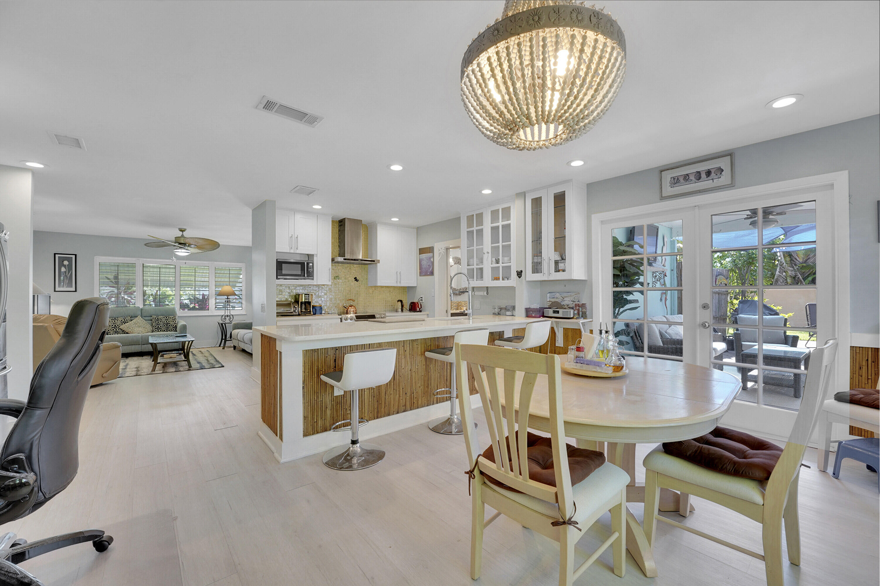 1708 Sunset Isles Road Fort Pierce, FL 34949 - Photo 17 of 52 a kitchen with stainless steel appliances kitchen island granite countertop a stove a sink a dining table and chairs