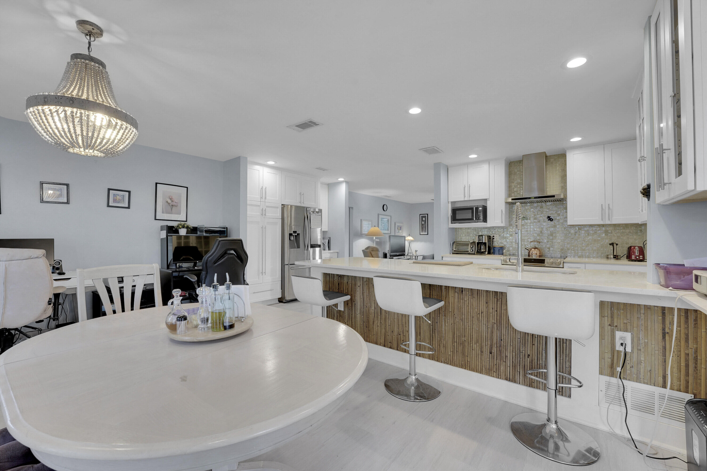 1708 Sunset Isles Road Fort Pierce, FL 34949 - Photo 26 of 52 a kitchen with stainless steel appliances a dining table chairs stove and cabinets