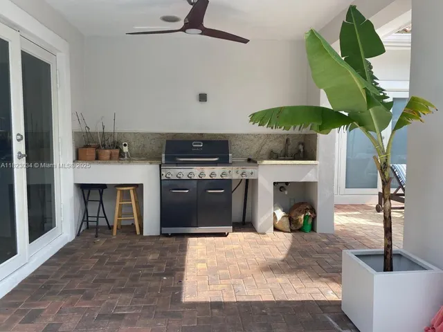 a kitchen with a chandelier a sink stainless steel appliances and a fireplace