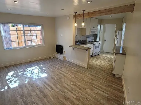 a kitchen with kitchen island granite countertop a stove and a wooden floor