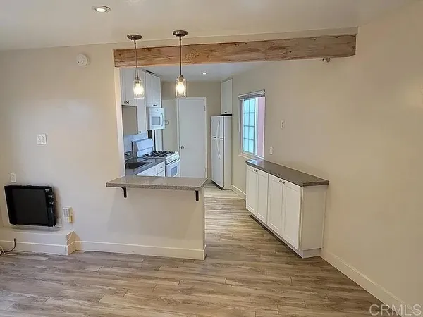 a view of a living room and kitchen with wooden floor
