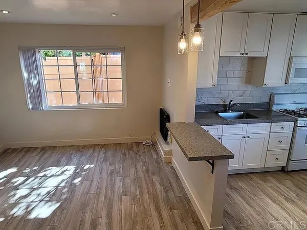 an empty room with wooden floor and window